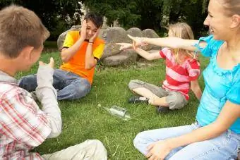 Tínedžeri hrajú hru s fľašou v parku