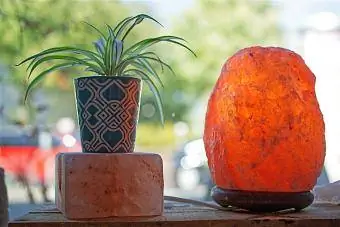 Растение и соляная лампа на деревянном ящике перед макросом окна