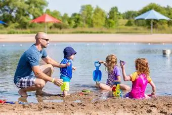 család játszik a tó strandján