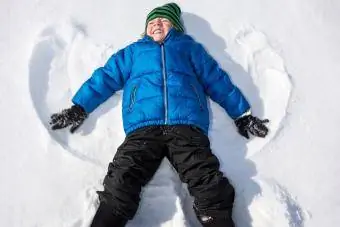 batang lalaki na gumagawa ng snow angel