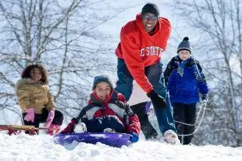 pamilya snow sledding pababa ng burol