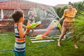 Familienspritzerei mit Wasserpistole im Garten