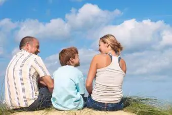 perhe katsomassa pilviä yhdessä