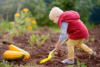 garçon nettoyant le jardin pour l'automne