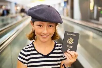 Meisie hou paspoort in lughawe