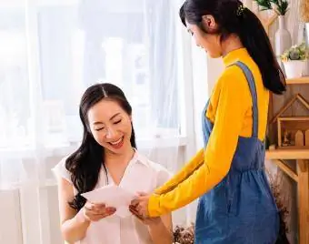 Smilende asiatisk mor og datter med kort