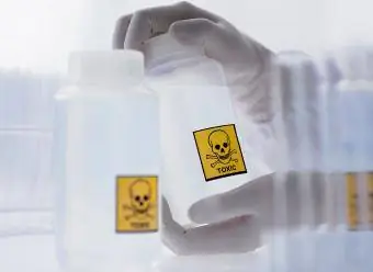 Tudós kezében mérgező címkével ellátott palack