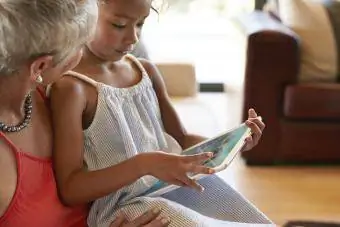 Νεαρό κορίτσι που παίζει παιχνίδι σε ψηφιακό tablet