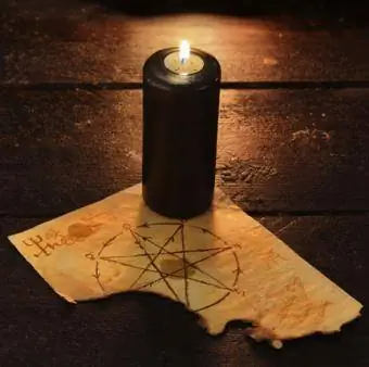 Zwarte kaars met pentagram op tafel