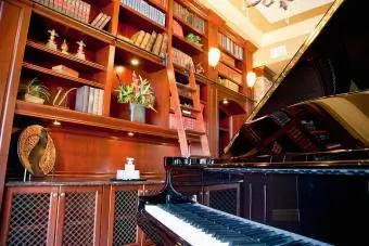 dhomë me rafte librash dhe piano