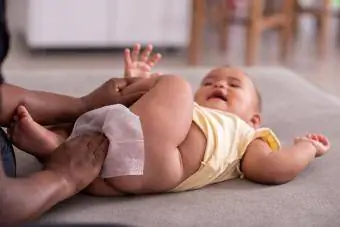 Ibu menyeka pantat bayi dengan tisu bayi