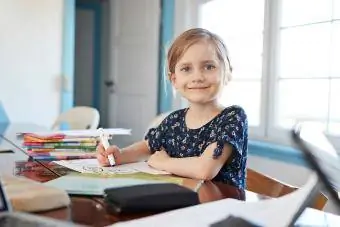 Portrét sebevědomá dívka dělá domácí úkoly u jídelního stolu