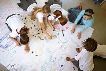Birlikte büyük bir çizim üzerinde çalışan çocuklar