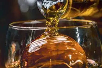 Liquore versato su una palla di ghiaccio in un bicchiere