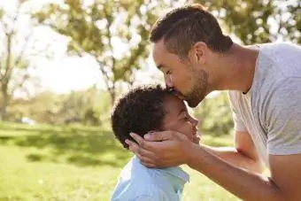 far kysser sønnens pande og viser støtte