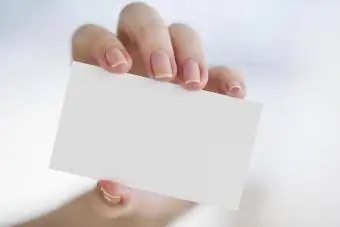 Mão segurando um cartão de visita em branco