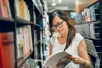 junge Dame liest Buch im Buchladen