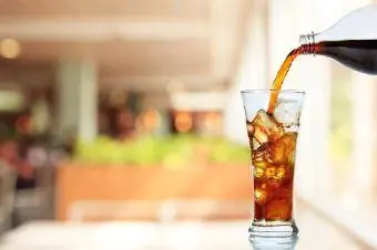 Botol soda menuang minuman dalam gelas