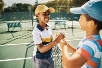 nakikipagkamay ang mga preteen pagkatapos ng laban ng tennis