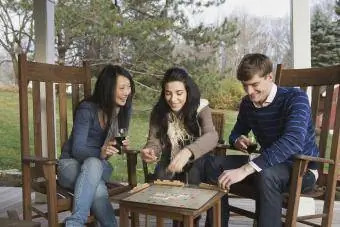 Amis jouant au scrabble sur le porche