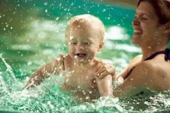 Mor plasker med baby søn i swimmingpool