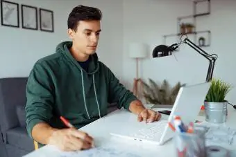 hombre frente a una computadora portátil asistiendo a clases en línea