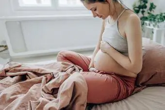 jovem futura mãe acariciando sua barriga