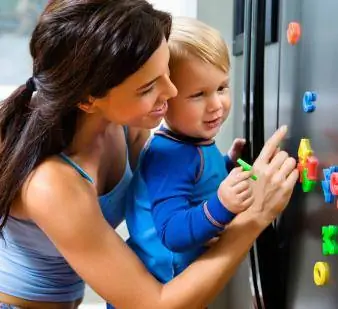 طفل وأم مع مغناطيس على الثلاجة