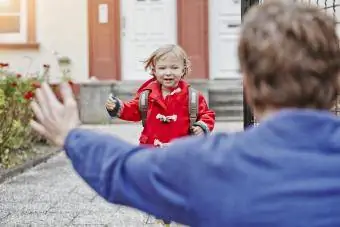 Šťastná dcera se blíží k otci u vchodu do domu