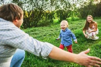 Ebeveynler yürümeye başlayan oğluyla açık havada oynuyor
