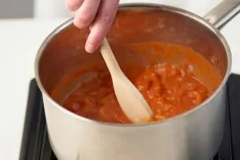 Remenar la salsa de xili per als tamales