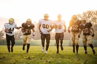 Joueurs de football américain courant sur le terrain de jeu.