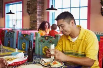 Homem comendo em restaurante mexicano