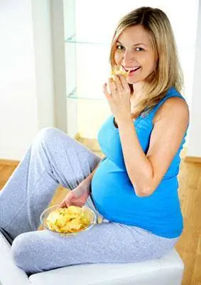 Mulher grávida come batatas fritas