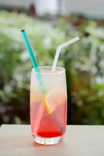 Minuman berwarna merah muda dengan hiasan lemon