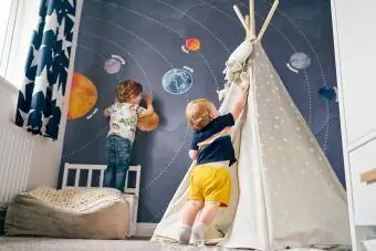 Bröder spelar på väggmålning av solsystemet