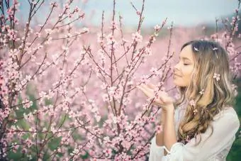 Femme posant dans un verger d'abricotiers au printemps