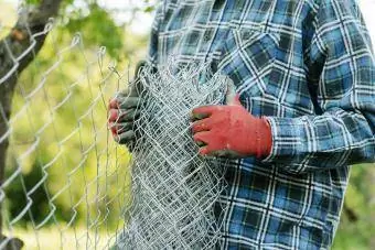 Homem construindo uma cerca protetora