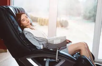 Женщина расслабляется на массажном кресле