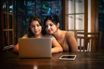 Anne, genç çocuğunun geceleri evde ödev yapmasına yardım ediyor