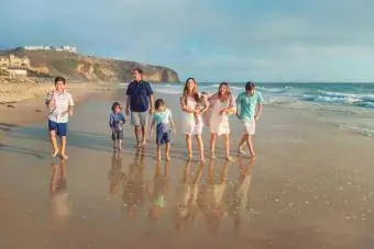 Keluarga campuran besar berjalan di pantai
