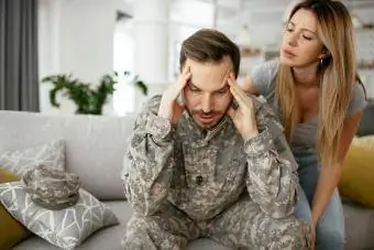 Przygnębiony żołnierz siedzi na kanapie z żoną