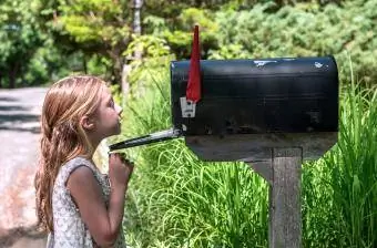 Fille regardant à l'intérieur d'une boîte aux lettres