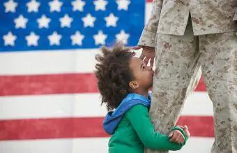 niña abrazando la pierna del soldado que regresa