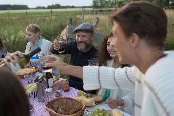 Familia bebiendo vino tinto y comiendo