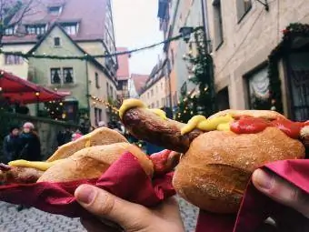 Kumakain ng bratwurst sa German Christmas market