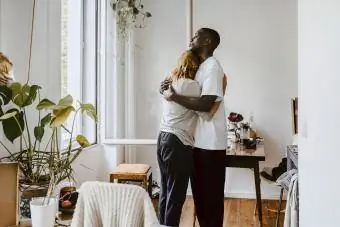 Mãe abraçando filho na sala