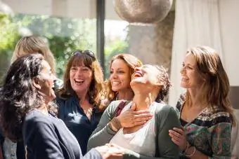 Mujeres en reunión saludando y sonriendo