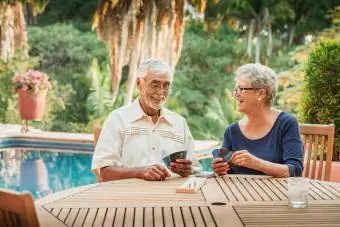 Pasangan Senior bermain cribbage di luar rumah