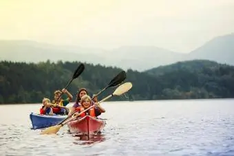 Ouders en zonen kanoën op het meer